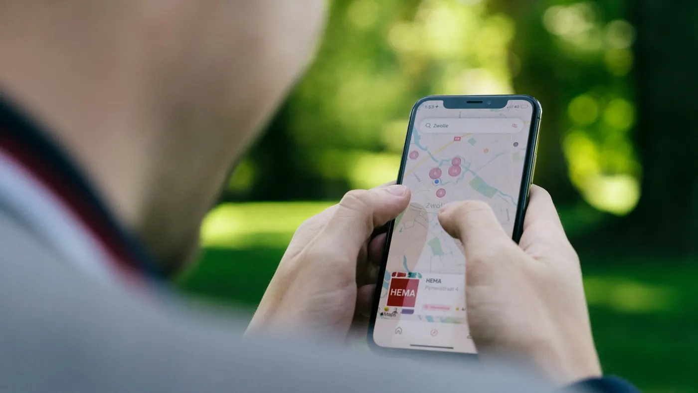 Mãos segurando o celular com o mapa da entrega aberto