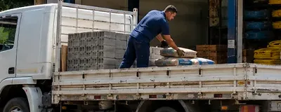 Material de construção sendo descarregado do caminhão na entrega.